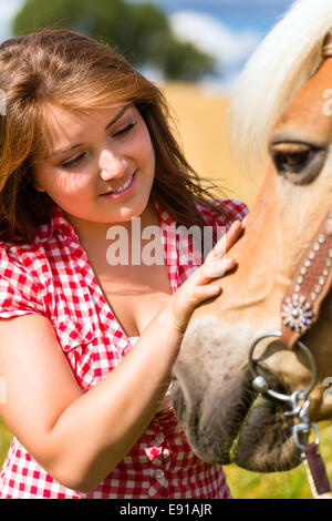 Donna petting cavallo su pony farm Foto Stock