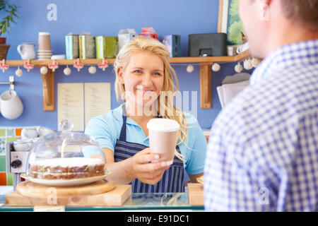 Cameriera In Cafe che serve il cliente con caffè Foto Stock