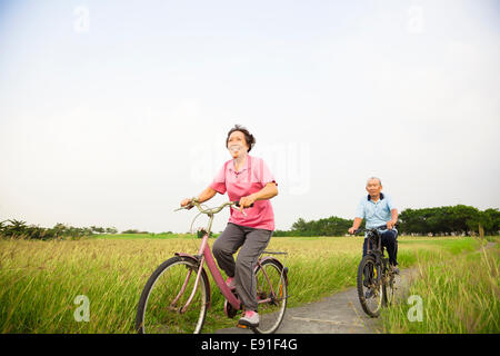 Felice Asian anziani anziani matura mountain bike nel parco Foto Stock