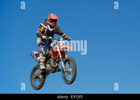 Motocicletta saltando contro il cielo blu Foto Stock