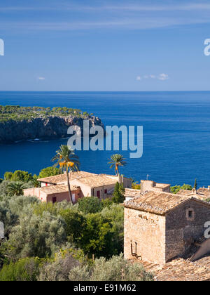Deià, Maiorca, isole Baleari, Spagna. Il piccolo borgo di Llucalcari, arroccato sopra il Mediterraneo. Foto Stock