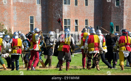 Herstmonceux, East Sussex, Inghilterra. Combattenti in costume rivivere un castello medievale assedio al Castello di Herstmonceux. Foto Stock