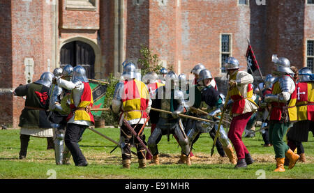 Herstmonceux, East Sussex, Inghilterra. Combattenti in costume rivivere un castello medievale assedio al Castello di Herstmonceux. Foto Stock