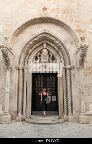 Donna entrando in Cattedrale di San Marco nella città di Korcula, Croazia 2014 Foto Stock