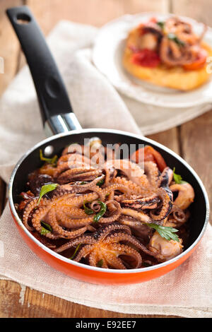 Il cibo italiano. Polipetti preparata con pomodori, aglio e prezzemolo. Foto Stock