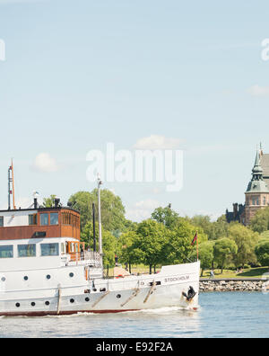 Traghetto passeggero passando Djurgården park e il museo Nordico a Stoccolma, Svezia Foto Stock