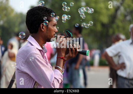 Bubble machine venditore soffiando bolle di sapone in aria in India Gate in New Delhi Foto Stock