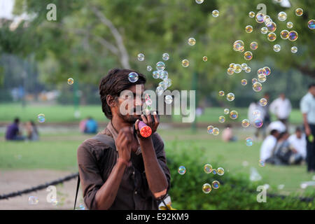 Bubble machine venditore soffiando bolle di sapone in aria in India Gate in New Delhi Foto Stock