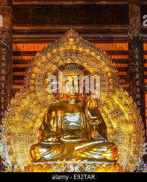 Cornice dorata gigante immagine del Buddha che accoglie i visitatori. Foto Stock