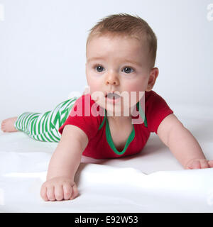 9 mese fa baby boy tenendo la sua testa indossando i colori di Natale Foto Stock
