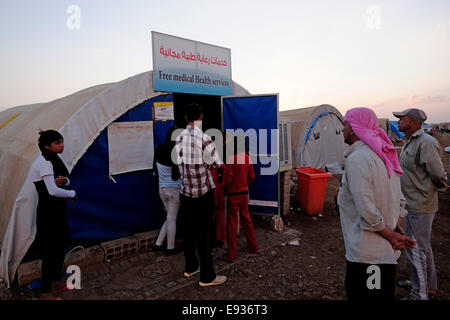 Yazidi di persone in coda per entrare in un mobile di clinica medica in Nawroz Refugee Camp che è stata inizialmente istituita per shelter Aramei spostato dall'attuale siria guerra civile poi occupata dagli sfollati dalla minoranza setta Yazidi, che fuggono dalla violenza nella città irachena di Sinjar situato vicino alla città di al-Malikyah in Rojava autonoma curda, regione nord-orientale della Siria. Foto Stock