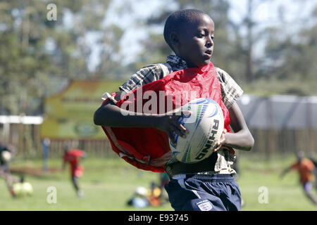 Kampala, Uganda. Ottobre 18th, 2014. Svantaggiati bambino ugandese prende il tempo per giocare a rugby. Molti dei giovani che vivono in baraccopoli hanno beneficiato in materia di istruzione attraverso i fondi di espatriati che amano lo sport. Credito: Sansone Opus/Alamy Live News Foto Stock