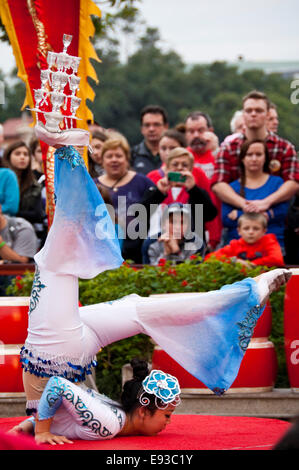 Ritratto verticale di un cinese contortionist acrobat durante una performance. Foto Stock