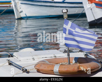 Sbiadita bandiera greca su una barca da pesca nel porto di Pythagorion a Samos in Grecia. Foto Stock