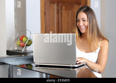 Imprenditore ragazza che lavora con un computer portatile in cucina a casa Foto Stock