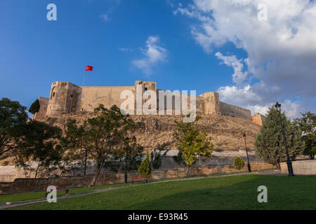 Il castello (Kale) di Gaziantep, la città più famoso punto di riferimento, al tramonto sotto un cielo blu. Anatolia sud-orientale, in Turchia. Foto Stock