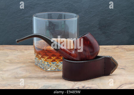 In legno tubo di fumo e whisky vetro su di un tavolo di legno Foto Stock