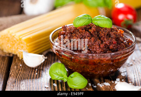 Pesto di pomodoro (con parmigiano e aglio) su sfondo di legno Foto Stock