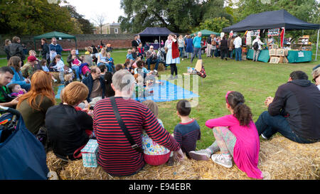 Fulham Palace; Londra UK. Il 19 ottobre 2014. Apple giorno celebrazioni hanno luogo a Fulham Palace. I bambini e le loro famiglie si radunano per ascoltare animato cantastorie Olivia Armstrong nei giardini presso il festival di pomeriggio. Credito: Kathy deWitt/Alamy Live News Foto Stock