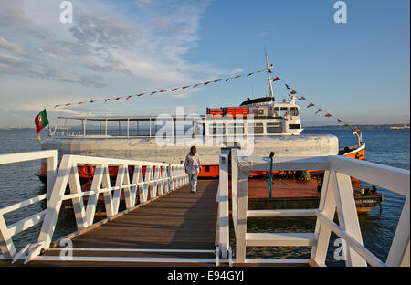 Giovane donna camminando sul ponte per la nave traghetto sul Tago, Tejo, fiume, Oceano Atlantico a Baixa Pombalina, Lisbona, Portogallo Foto Stock