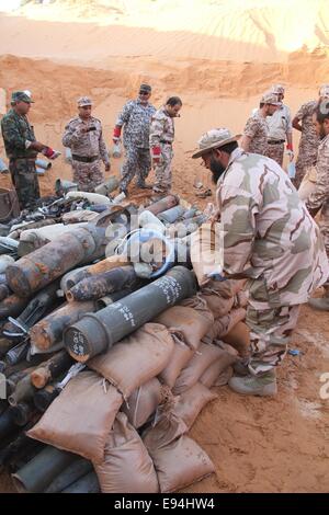 Tripoli, Libia. Xix oct, 2014. I sappers e alcuni soldati pila alcuni sacchi di sabbia sotto i gusci inesplose vicino a Tripoli, in Libia, il Ott 19, 2014. Un team della Libyan sappers domenica raccolti e la detonazione di un lotto di ordigni gusci lasciati dai belligeranti gruppi militanti nei pressi della capitale città di Tripoli. Credito: Hamza Turkia/Xinhua/Alamy Live News Foto Stock