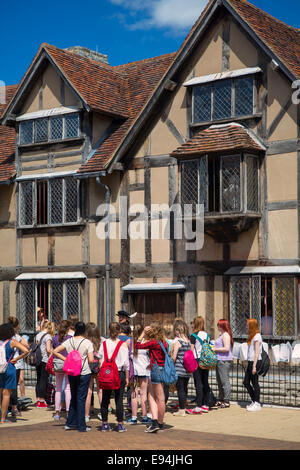 Un gruppo di ragazzi in età scolare ascoltare un attore sotto Wm Shakespeare home in Strattford Upon Avon, Warwickshire, il Costwolds, Inghilterra Foto Stock
