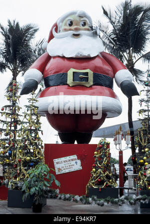 Una torreggiante Santa Claus visualizzare auguri agli acquirenti un Hawaiian Merry Christmas (Mele Kalikimaka) all'Ala Moana Center di Honolulu e Oahu, Hawaii, Stati Uniti d'America. Foto Stock