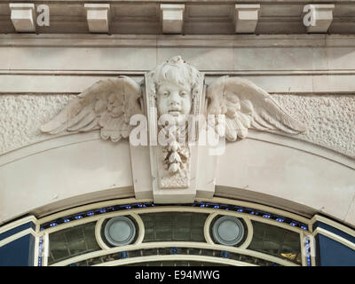 Decorativi in pietra scultura di un cherubino alato al di sopra di una ormai chiuso porta ingresso in stazione Waterloo di Londra, UK la più trafficata Stazione ferroviaria Foto Stock