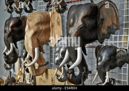 Legno complessamente intarsiato teste di elefante per la vendita su un mercato thailandese stallo. Thailandia SUDEST ASIATICO Foto Stock