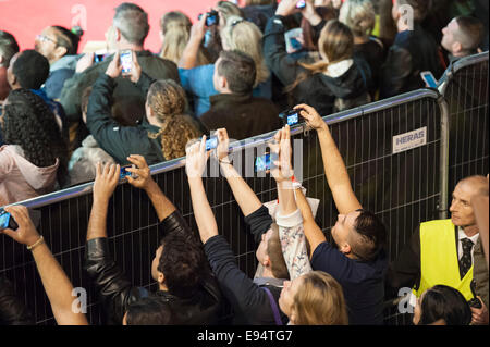 Leicester Square, Londra, Regno Unito. Il 19 ottobre 2014. La European film premiere della furia interpretato da Brad Pitt ha luogo presso il cinema Odeon di Leicester Square, Londra. Nella foto: tifosi fuori il tappeto rosso recinzioni perimetrali cerco di catturare Brad Pitt sui loro smartphone. Foto Stock