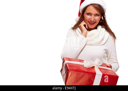 Pretty Woman in una festa di Santa Red hat con un grande rosso corrispondente regalo di Natale legate con un nastro e la prua tenendola davanti Foto Stock
