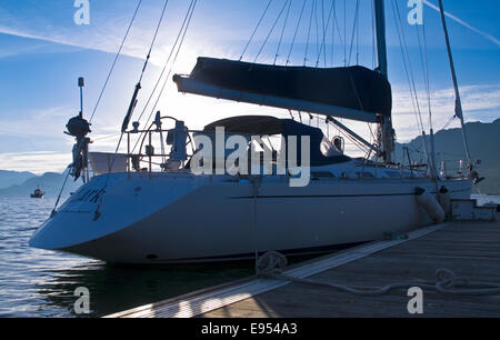 Yacht ormeggiati a Plockton Harbour visto contro Rising Sun, bella mattina di mezza estate, Loch Carron, Highlands scozzesi, Scozia Foto Stock