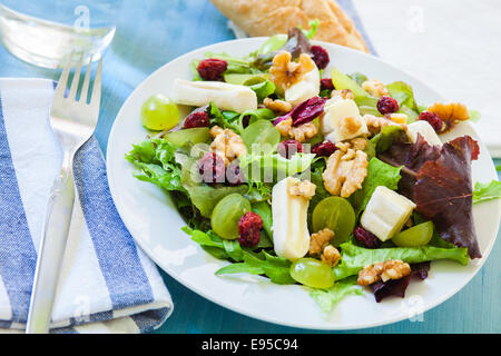 Mescolare con insalata di uva, frutta rossa, il formaggio e i dadi sulla ciotola bianco Foto Stock