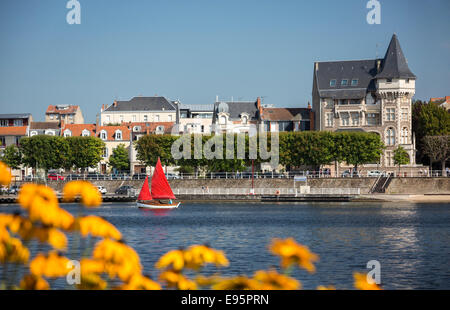 In estate, una rossa piccola barca a vela sul lago Allier (Vichy). Petit voilier à voiles rouges sur le Lac d'Allier, à Vichy. Foto Stock