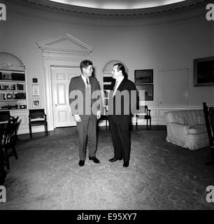 Questa fotografia mostra il presidente John F. Kennedy con un visitatore non identificato, probabilmente da una riunione formale o un evento. L'immagine cattura un momento significativo nei primi anni '1960, durante la presidenza di Kennedy. Foto Stock