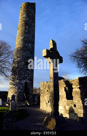 Luce della Sera sulla croce di Muiredach e torre rotonda del X secolo la testa ruota cross a Monasterboice contea di Louth in Irlanda Foto Stock