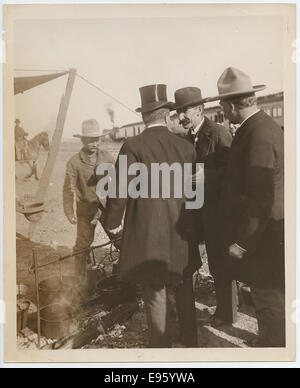 Questa fotografia raffigura una scena della colazione con cowboy in Colorado, tra cui personaggi famosi come Theodore Roosevelt. Cattura lo stile di vita dei cowboy, i falò e i carri trainati tipici dell'ovest americano alla fine del XIX secolo. Foto Stock