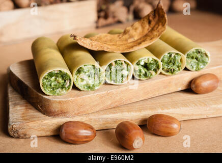 Materie cennellioni pasta spinaci e mozzarella formaggio come vegan o vegetariano su tavola di legno con decorazione di autunno Foto Stock