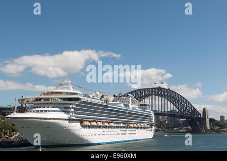 Una nave da crociera ormeggiata nel porto di Sydney con il Ponte del Porto di Sydney che si profila dietro di esso. Foto Stock