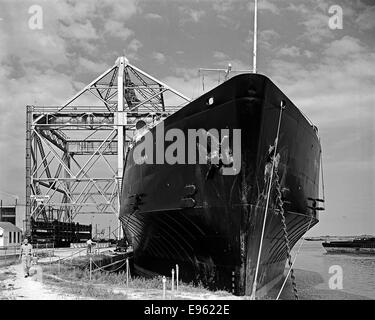 Questa fotografia mostra la prua della SS Seatrain Louisiana, una nave cargo gestita da Seatrain Lines, presso il molo della raffineria. L'immagine evidenzia lo scopo industriale della nave e il suo collegamento alle operazioni di trasporto marittimo di merci. Foto Stock