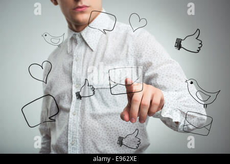 Giovane uomo premendo un icona virtuale mail in aria Foto Stock