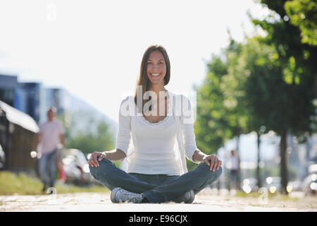 Lo yoga a sunny street Foto Stock