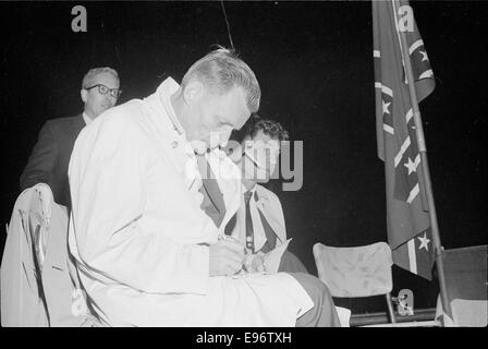 Fotografia che documenta un raduno del Ku Klux Klan (KKK) tenutosi nel 1965. L'immagine cattura i membri del gruppo durante una protesta o una dimostrazione, mostrando il loro abbigliamento e le loro insegne distintive. La fotografia riflette un capitolo oscuro della storia americana, documentando la presenza continua dei movimenti di supremazia bianca durante l'era dei diritti civili. Foto Stock