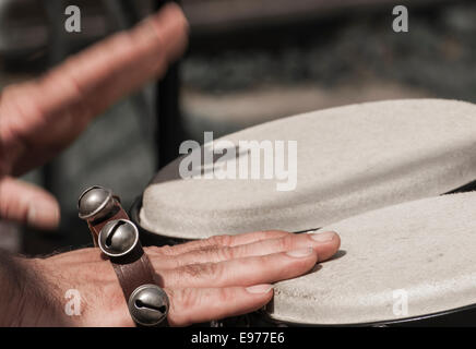 Close up di un percussionista con le mani in mano a giocare i tamburi di bongo. Foto Stock