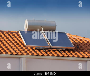 Calorifero di acqua solare sul tetto della piastrella con tetto di casa Foto Stock