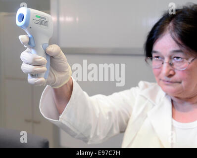 Praga, Repubblica Ceca. Xxi oct, 2014. Il personale medico dimostra tenendo la temperatura di un passeggero a Vaclav Havel Aeroporto di Praga Repubblica Ceca, Ottobre 21, 2014. Repubblica ceca introduce lo screening di passeggeri negli sforzi tesi a prevenire la diffusione del virus di Ebola. Credito: Roman Vondrous/CTK foto/Alamy Live News Foto Stock