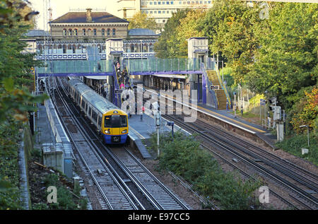 Denmark Hill stazione ferroviaria nel sud est di Londra. Un treno Overground attende alla piattaforma. Mostra nuovi impianti di risalita e passerella. Foto Stock