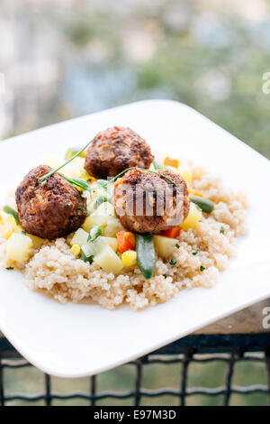 Piastra wit palline di carne e cous cous con verdure,fuoco selettivo Foto Stock