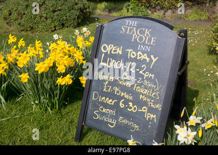 Stackpole Inn cartello fuori pub pubblicità cibo al sacco cena con narcisi Stackpole Pembrokeshire Wales UK Foto Stock