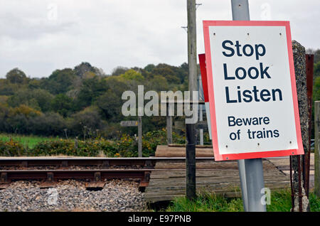 Cartelli di avvertimento ad una fattoria o professione passaggio a livello su una singola traccia rurale linea ferroviaria in Inghilterra. Foto Stock